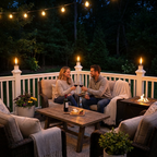  deck at night with a couple enjoying wine and talking. The white PVC deck has BuzzCaps to create a warm torch glow and repel mosquitos
