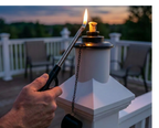 Person lighting a BuzzCap on a railing with a sunset in the background.

